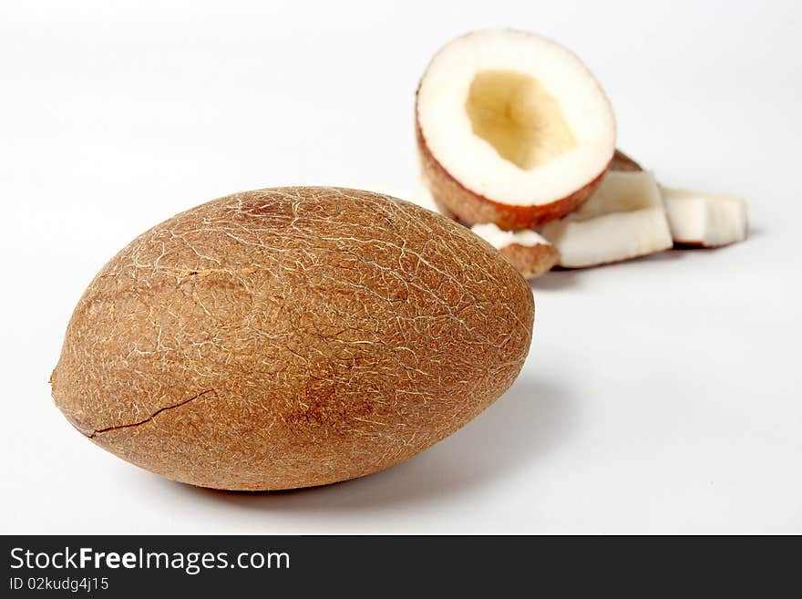 Unshelled coconut on white background with some pieces of nut