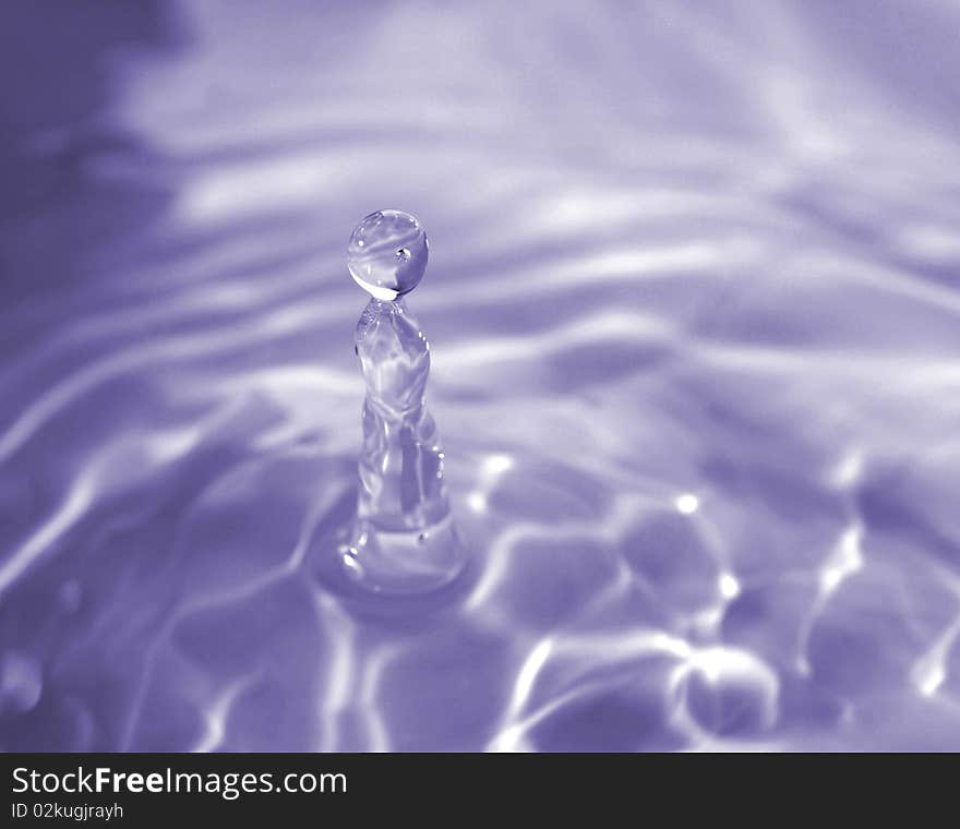 A water droplet frozen in motion moments before hitting the water