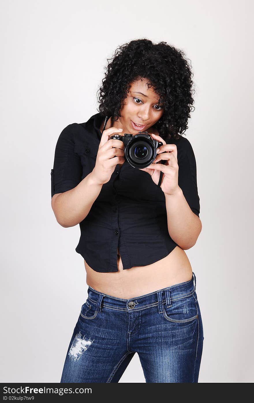 A pretty Hispanic woman looking at her new camera to find the right
setting for the next picture, in a black blouse and jeans, over light gray. A pretty Hispanic woman looking at her new camera to find the right
setting for the next picture, in a black blouse and jeans, over light gray.