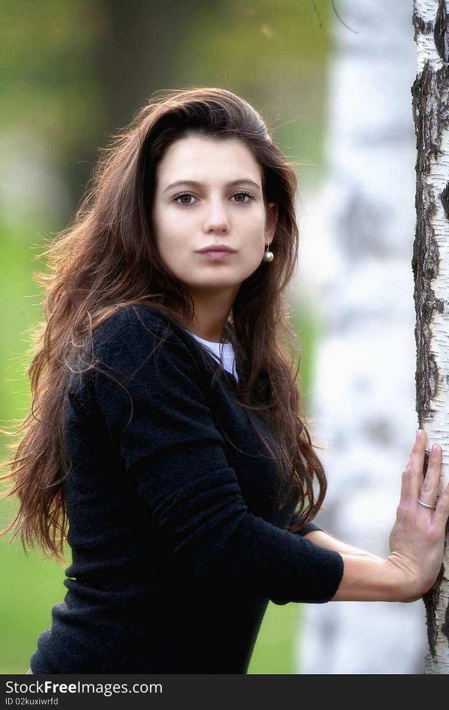 Portrait of a beautiful brunette standing in birch forest. Portrait of a beautiful brunette standing in birch forest