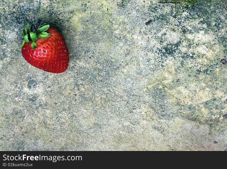 Beautiful red strawberry on textured grunge rock. Beautiful red strawberry on textured grunge rock