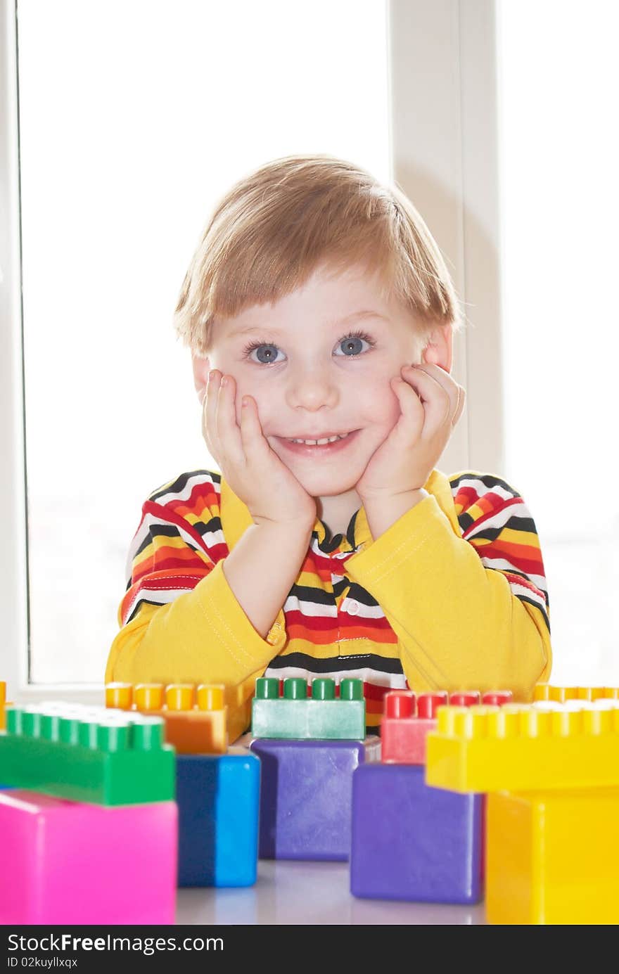 The beautiful little boy poses on a light background. The beautiful little boy poses on a light background