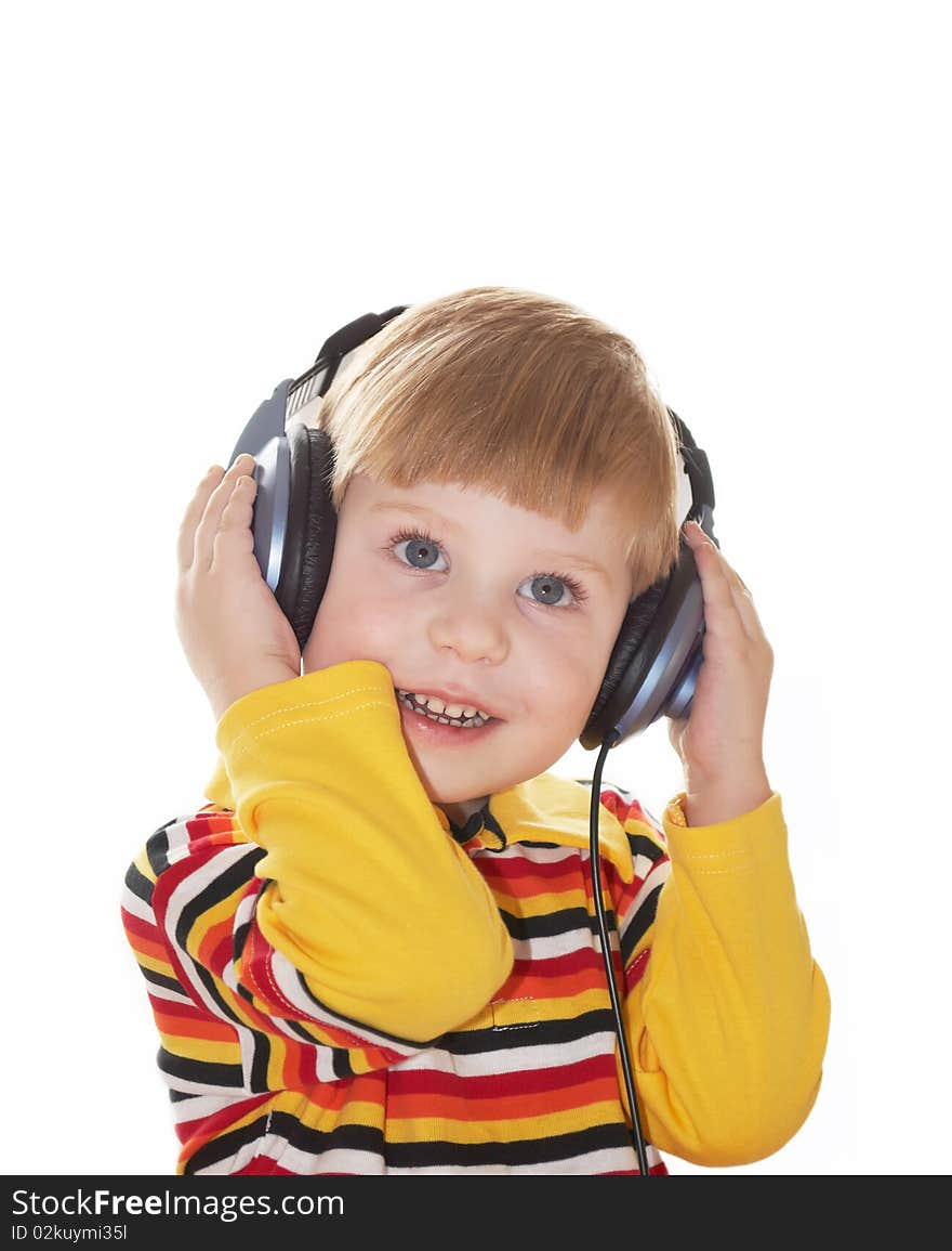 The little boy in headphones listens to music on a white background. The little boy in headphones listens to music on a white background