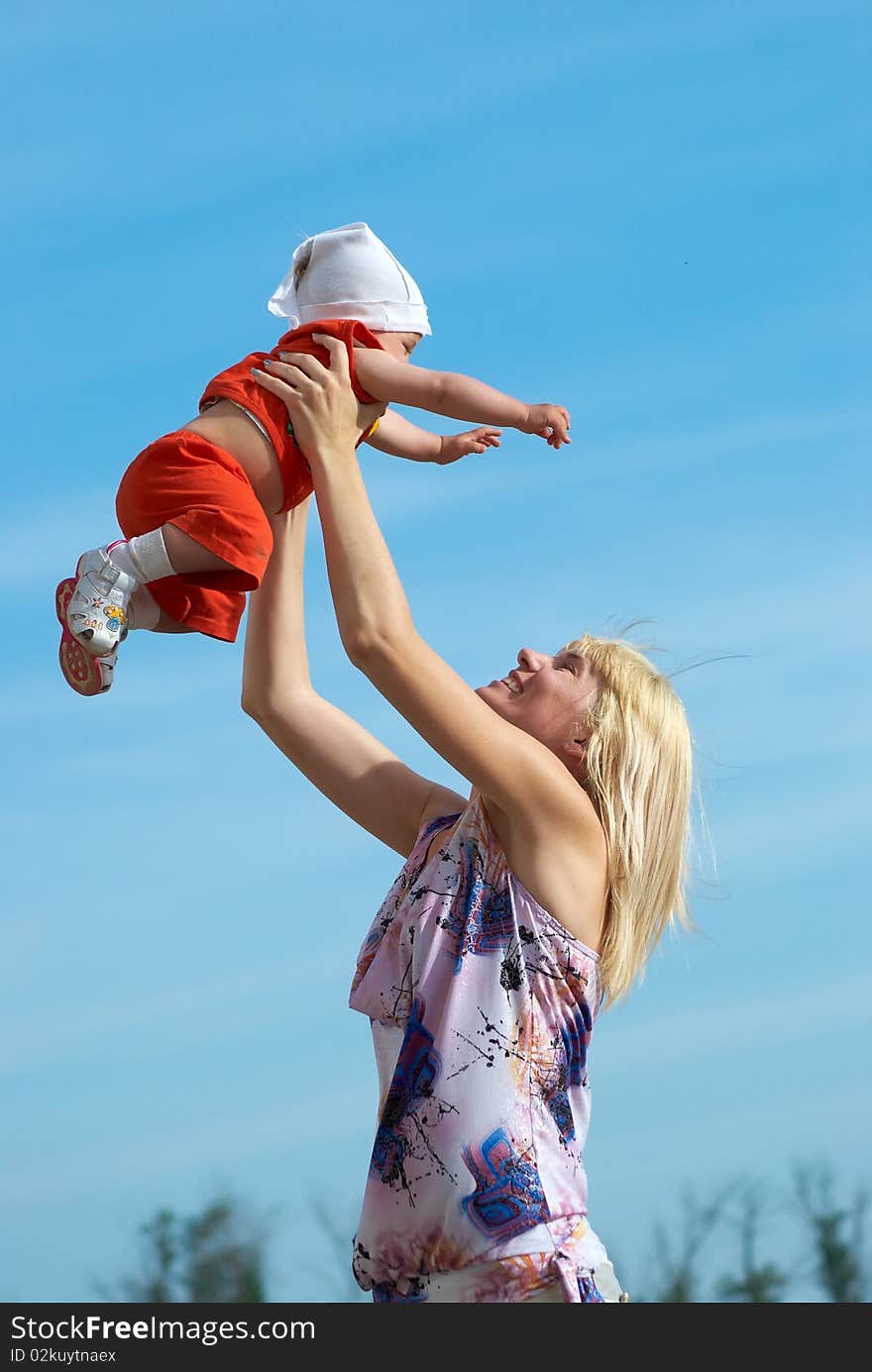 Mother with baby under blue clear sky. Mother with baby under blue clear sky