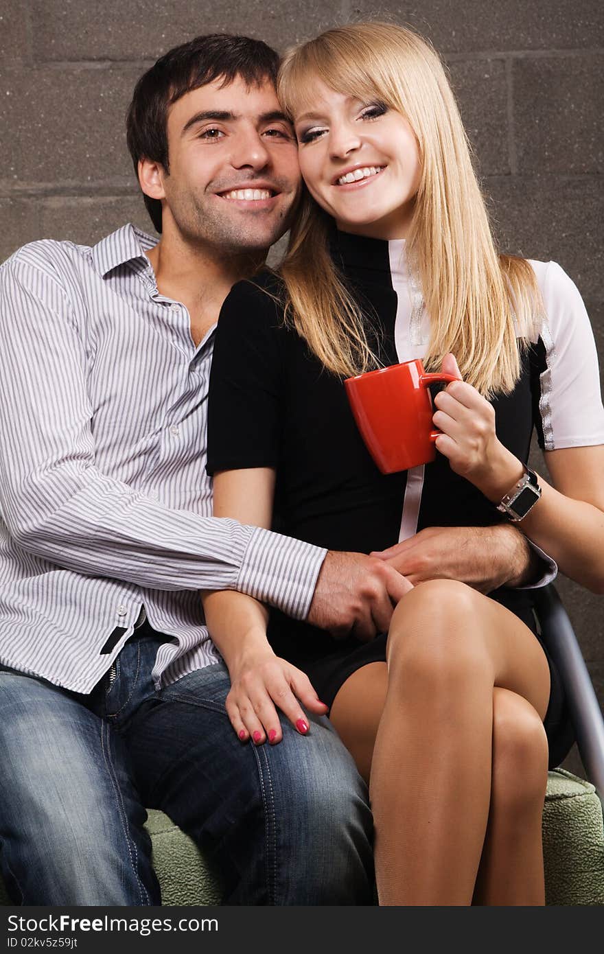 Young cheerful couple on brick wall background