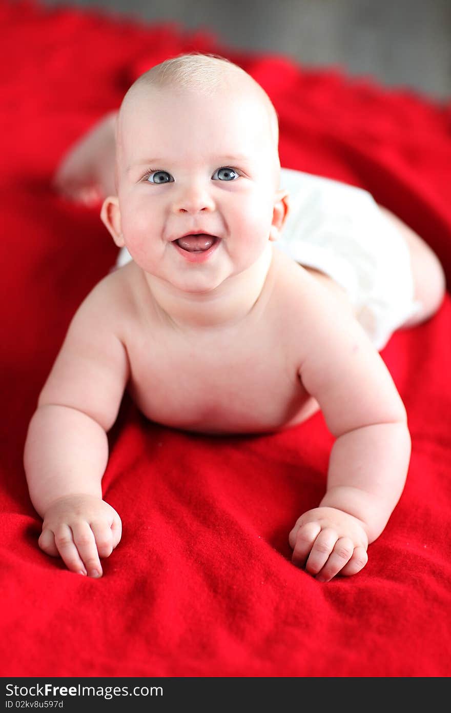 Little boy lying on red bed blanket. Little boy lying on red bed blanket.