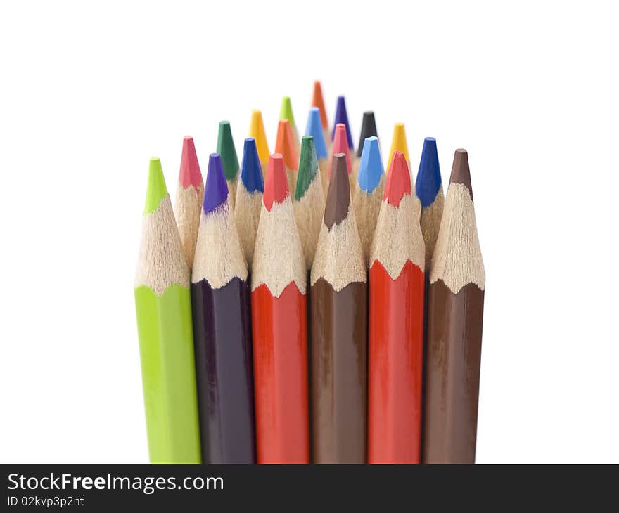 Several colored pencils stand together forming a triangle shape. Several colored pencils stand together forming a triangle shape.