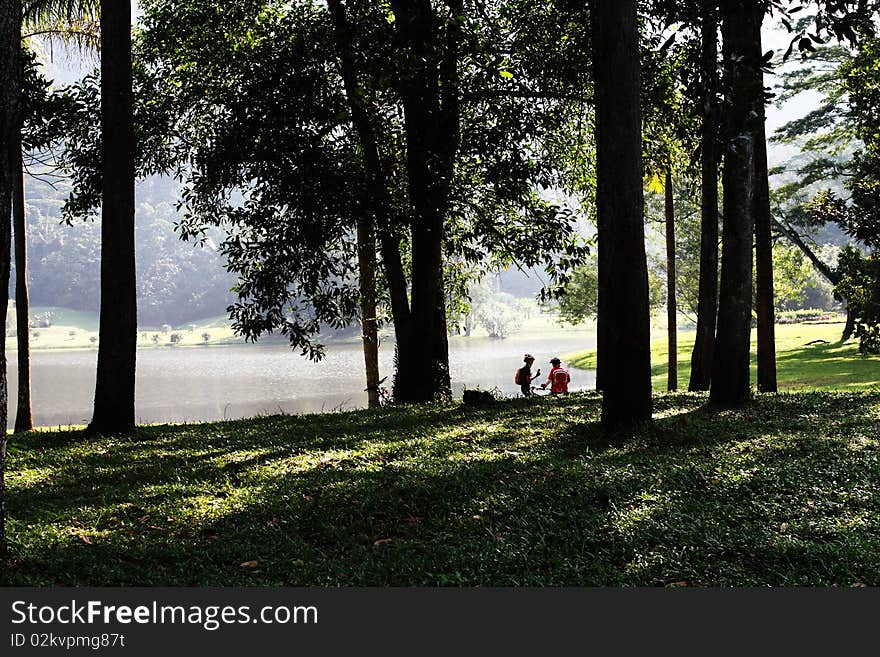 Cyclists taking a break by a Lake in A Botanical Garden. Cyclists taking a break by a Lake in A Botanical Garden