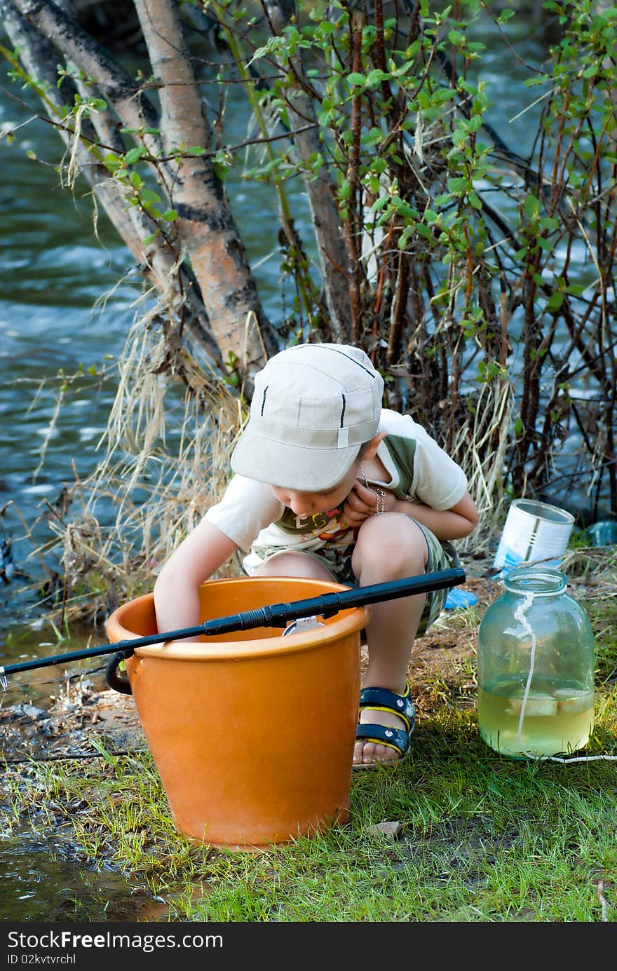 The boy examines the caught fish