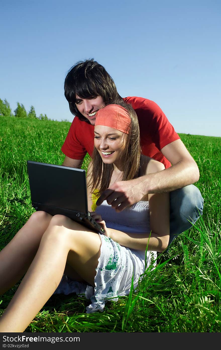 Beautiful girl with notebook and boy with smile on grass. Beautiful girl with notebook and boy with smile on grass