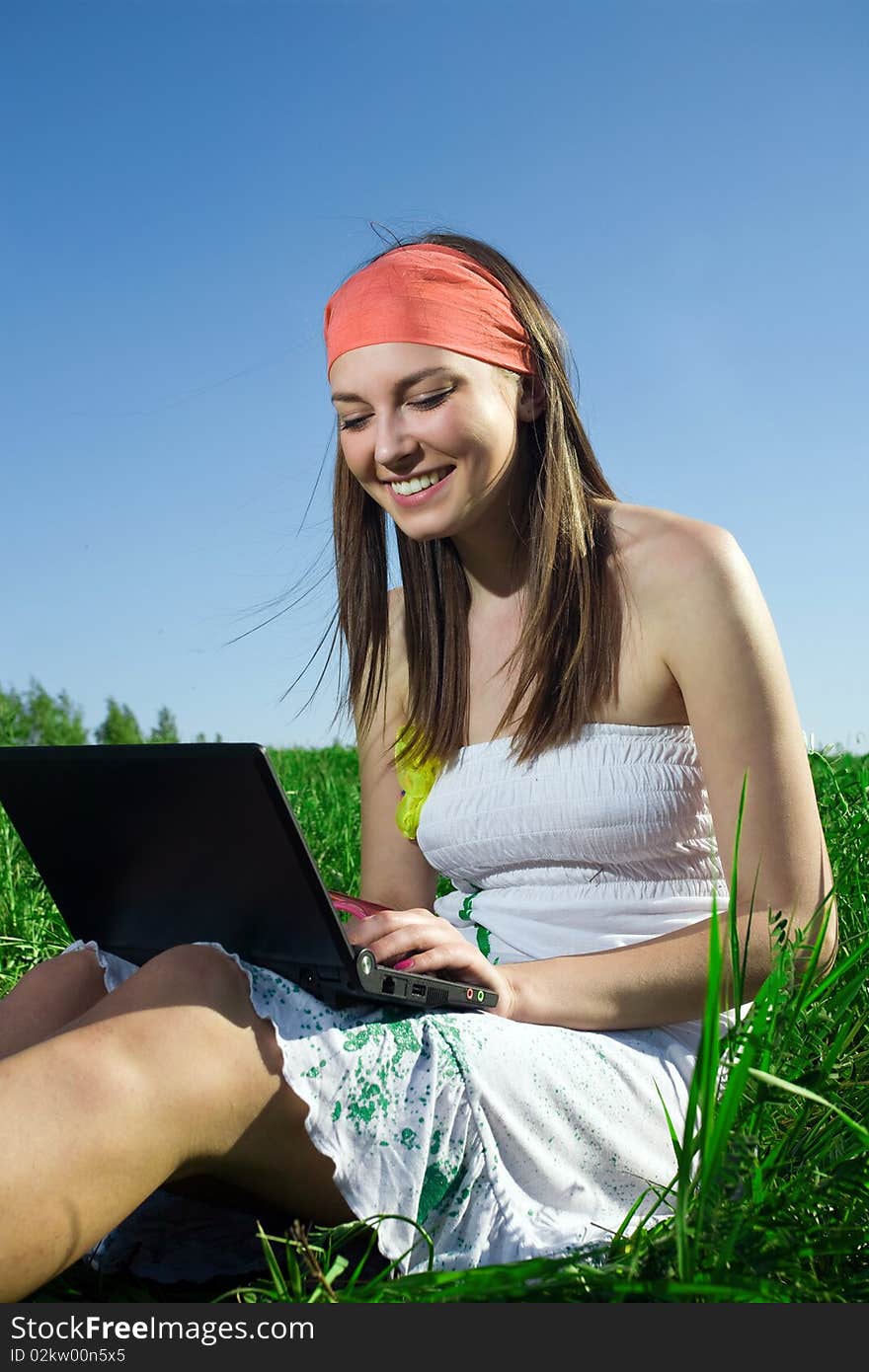 Beautiful girl with notebook on grass