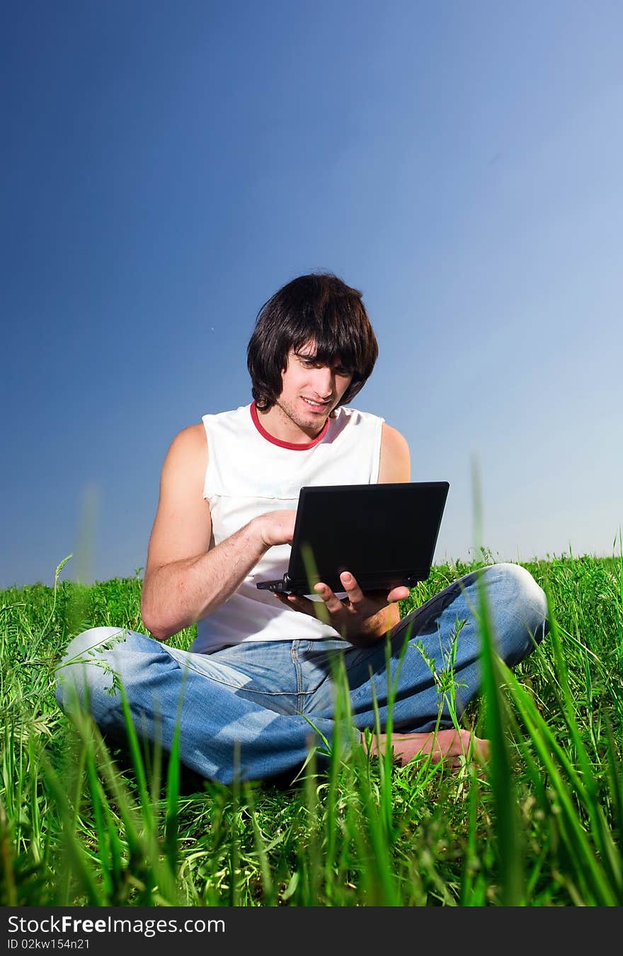 Boy with notebook on grass