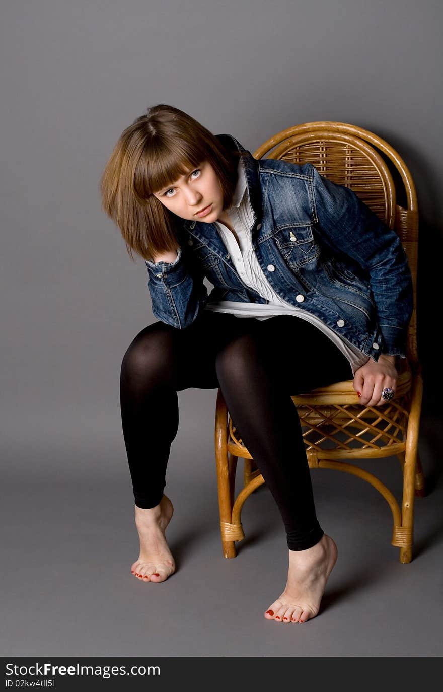 Attractive girl sitting on chair in studio