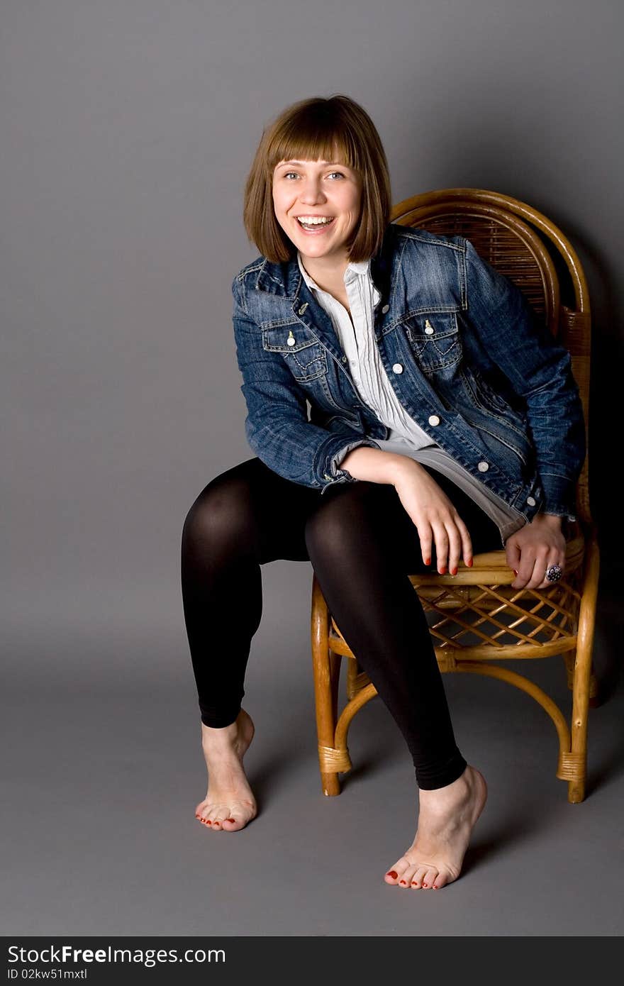 Attractive girl sitting on chair in studio