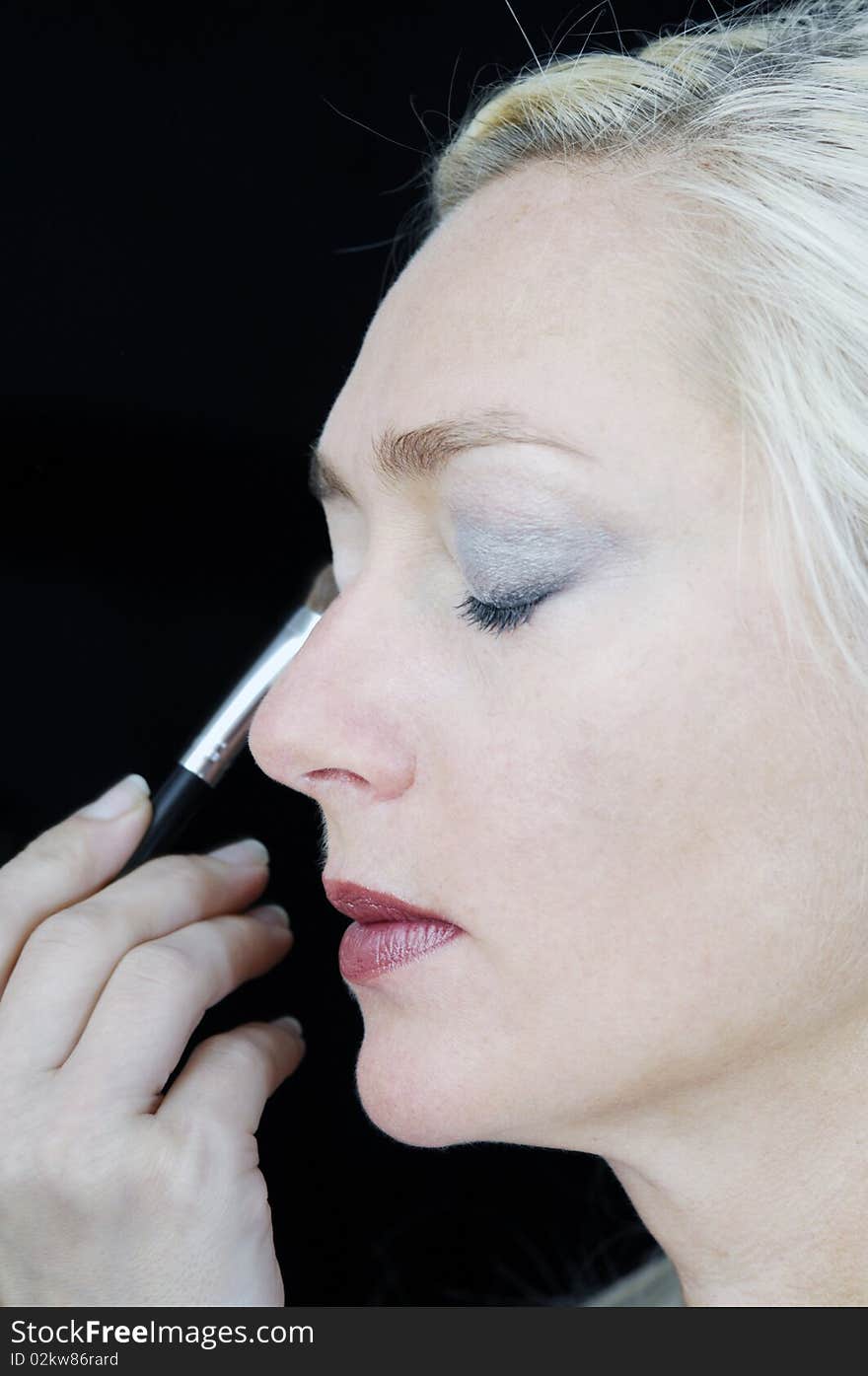 Middle aged woman gets make up applied tyo her face at the beauty salon. Middle aged woman gets make up applied tyo her face at the beauty salon.