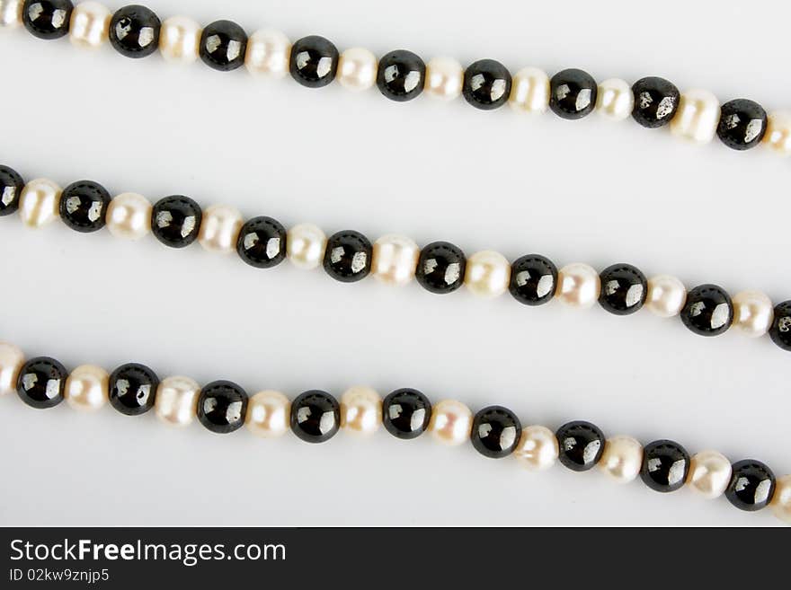 White pearls and black stone beads on a thread. White pearls and black stone beads on a thread