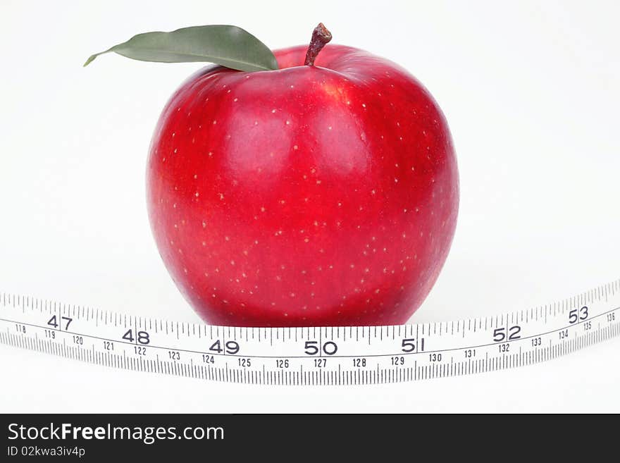 Red apple and measuring tape on a white background