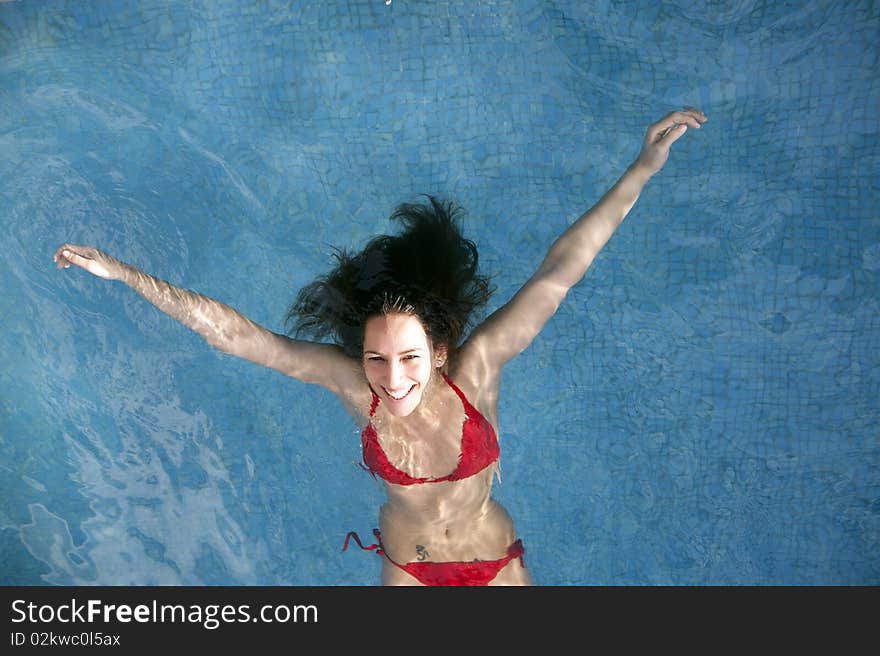 Beautiful woman floating on swimming pool. Beautiful woman floating on swimming pool