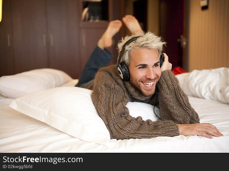 Man listening music with headphones at home.