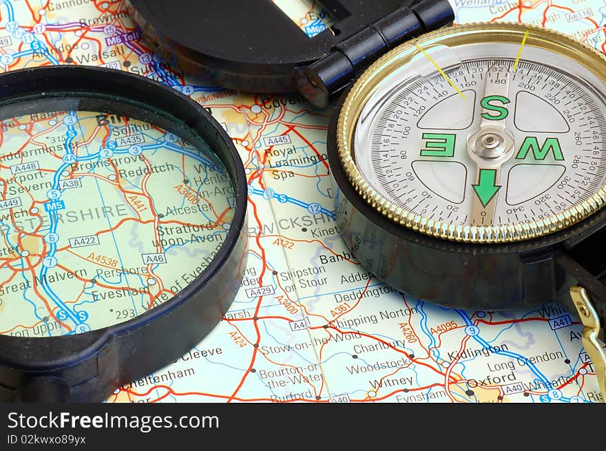 Compass and magnifier on a map for travel by close up. Compass and magnifier on a map for travel by close up