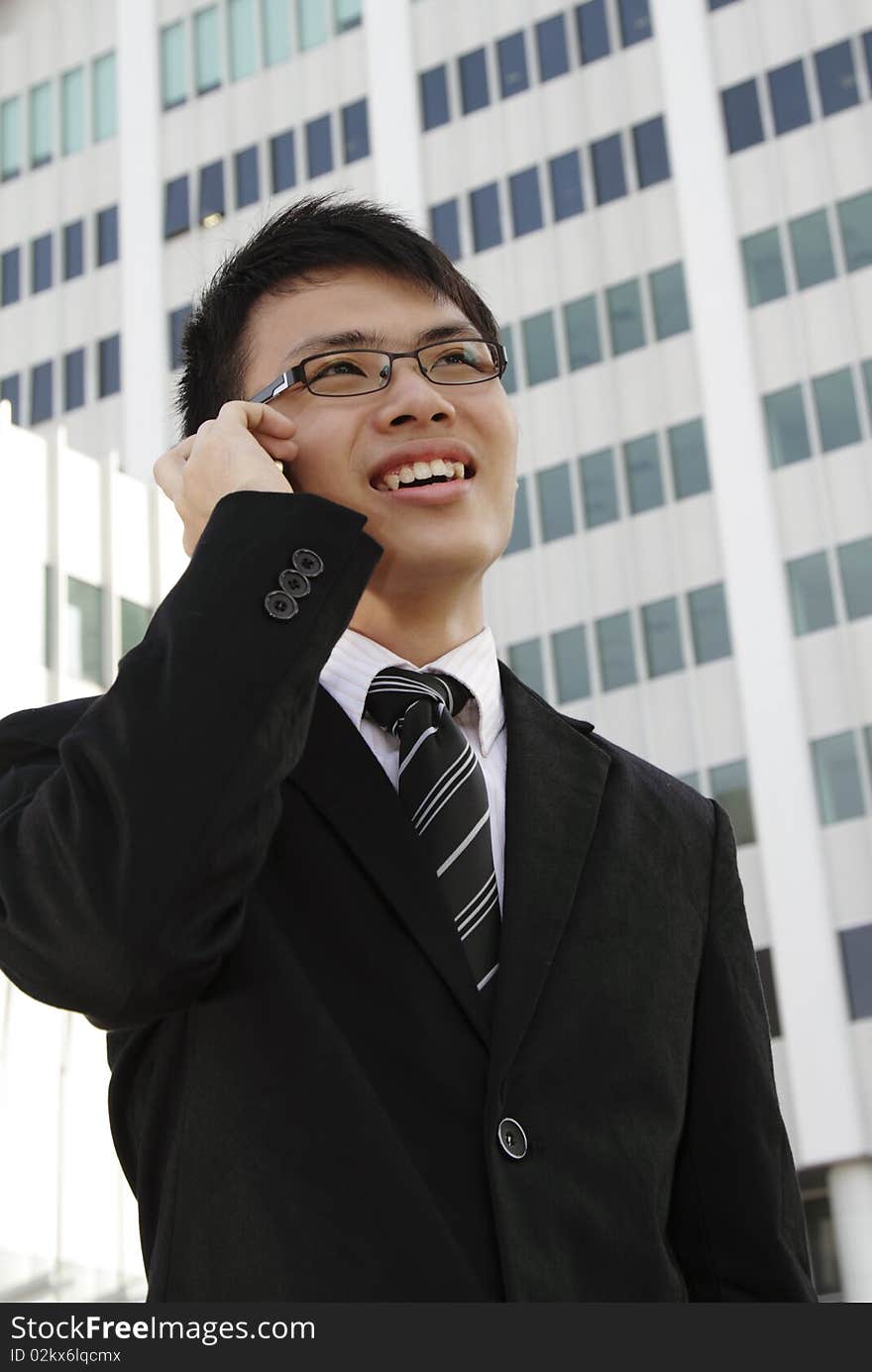 A young Asian businessman speaking on the phone