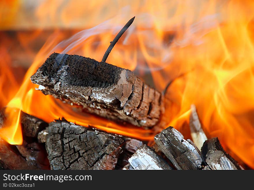 Black nail against red fire. Black nail against red fire