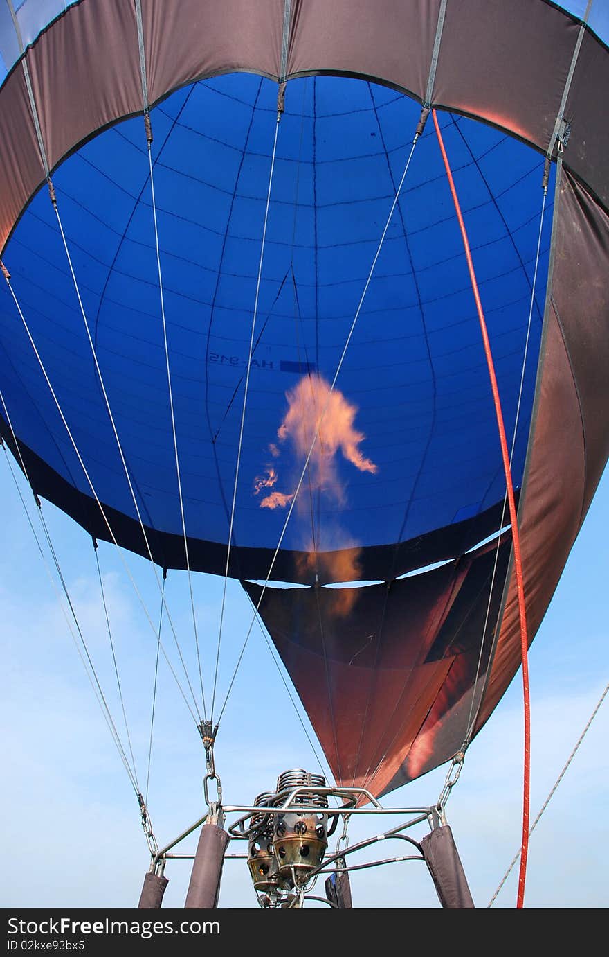 Closeup with hot air balloon and flames getting ready to fly away in the air