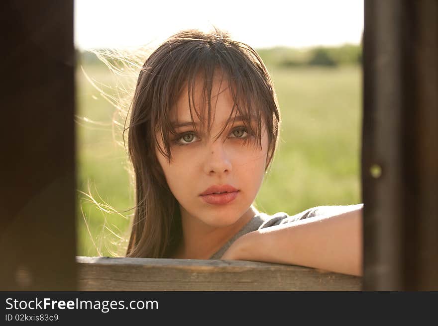 A portrait of a lovely young model standing outside a corrugated tin shed, taken with the photographer standing inside the shed, with walls of the shed framing her face. A portrait of a lovely young model standing outside a corrugated tin shed, taken with the photographer standing inside the shed, with walls of the shed framing her face