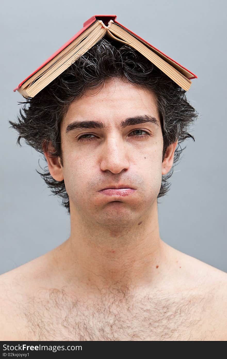 Bored lazy college student with a book on his head