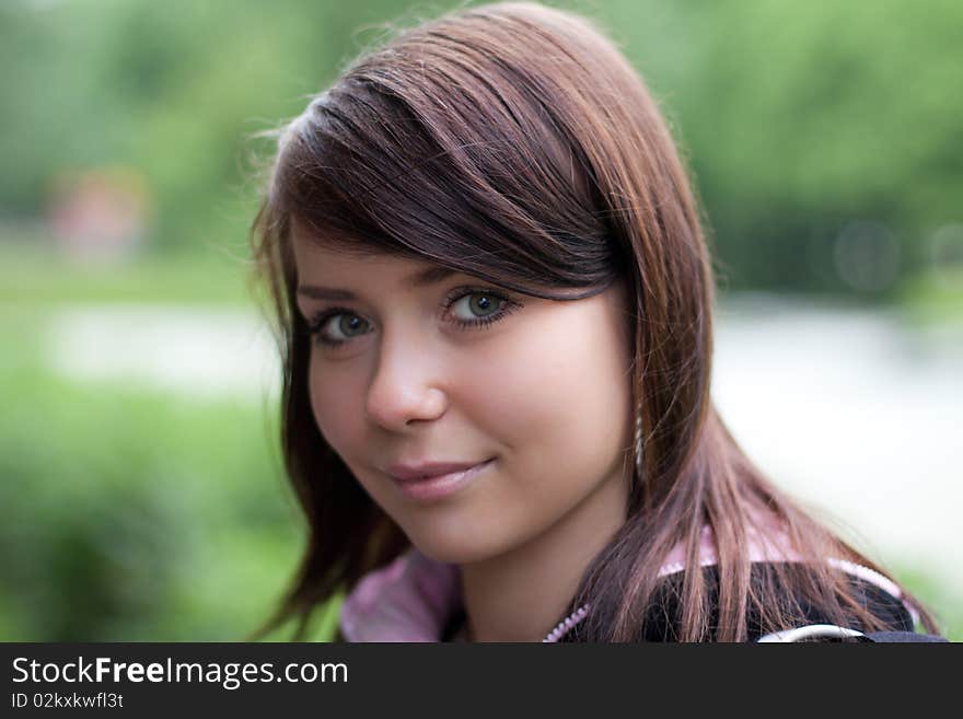 Portrait of the girl outdoors on the green bokeh  background in summer