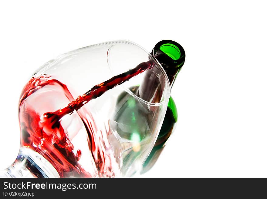 Red wine pouring down from a wine bottle against white background