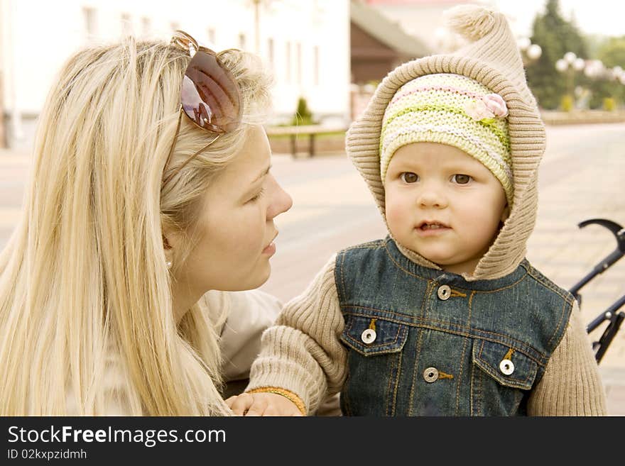 Mum explains something to the child which costs nearby and listens. Mum explains something to the child which costs nearby and listens