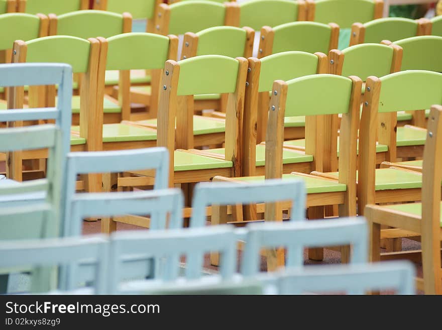 Pciture of wooden green and blue chairs put in straight rows in a kindergarten for a celebration. Pciture of wooden green and blue chairs put in straight rows in a kindergarten for a celebration