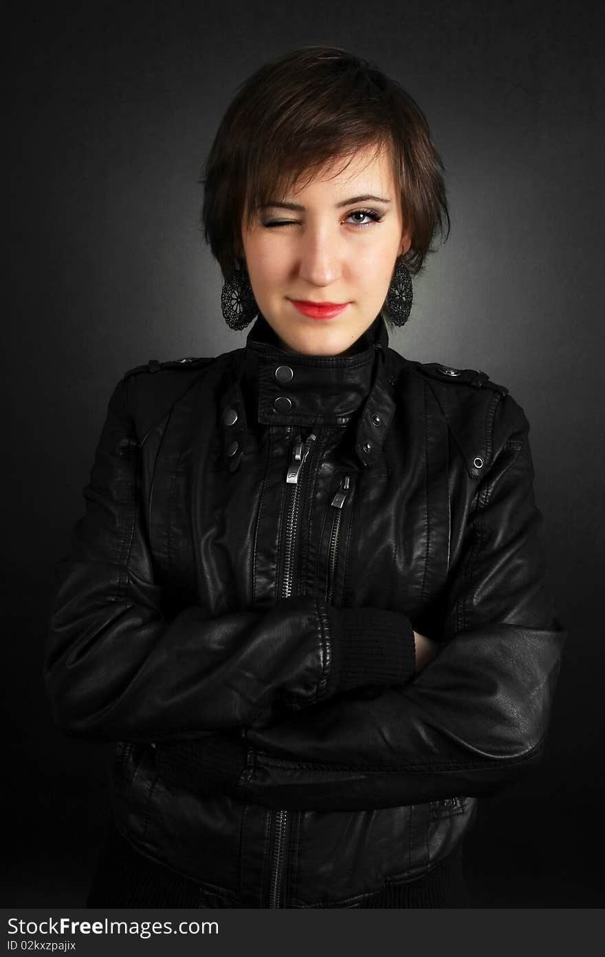 Rock girl in leather outfit smiling on black background