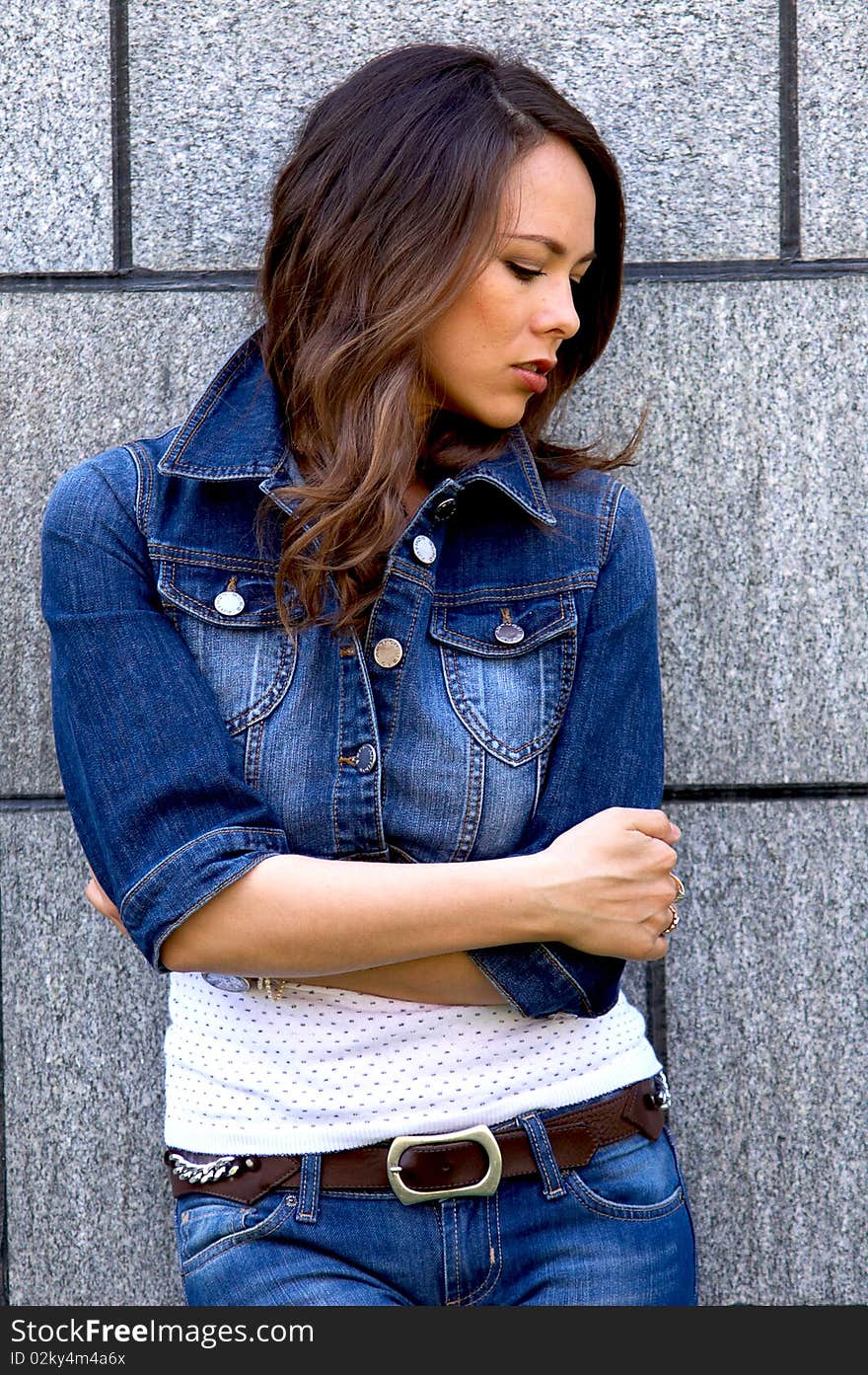 Young beautiful woman staying near the wall. Young beautiful woman staying near the wall