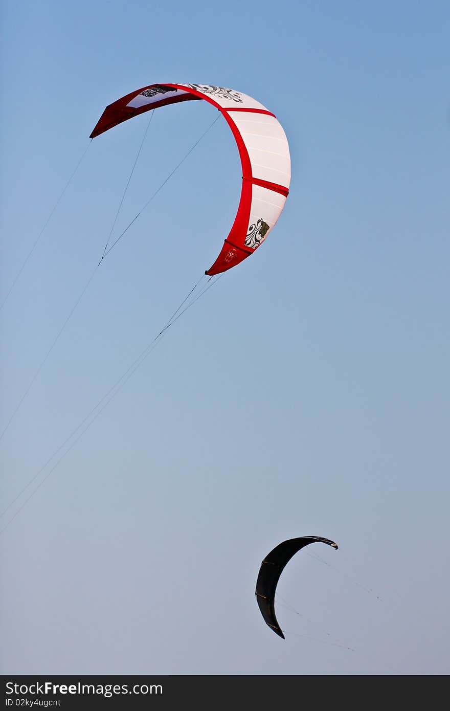 2 flying kites are in the air on opposite direction. 2 flying kites are in the air on opposite direction