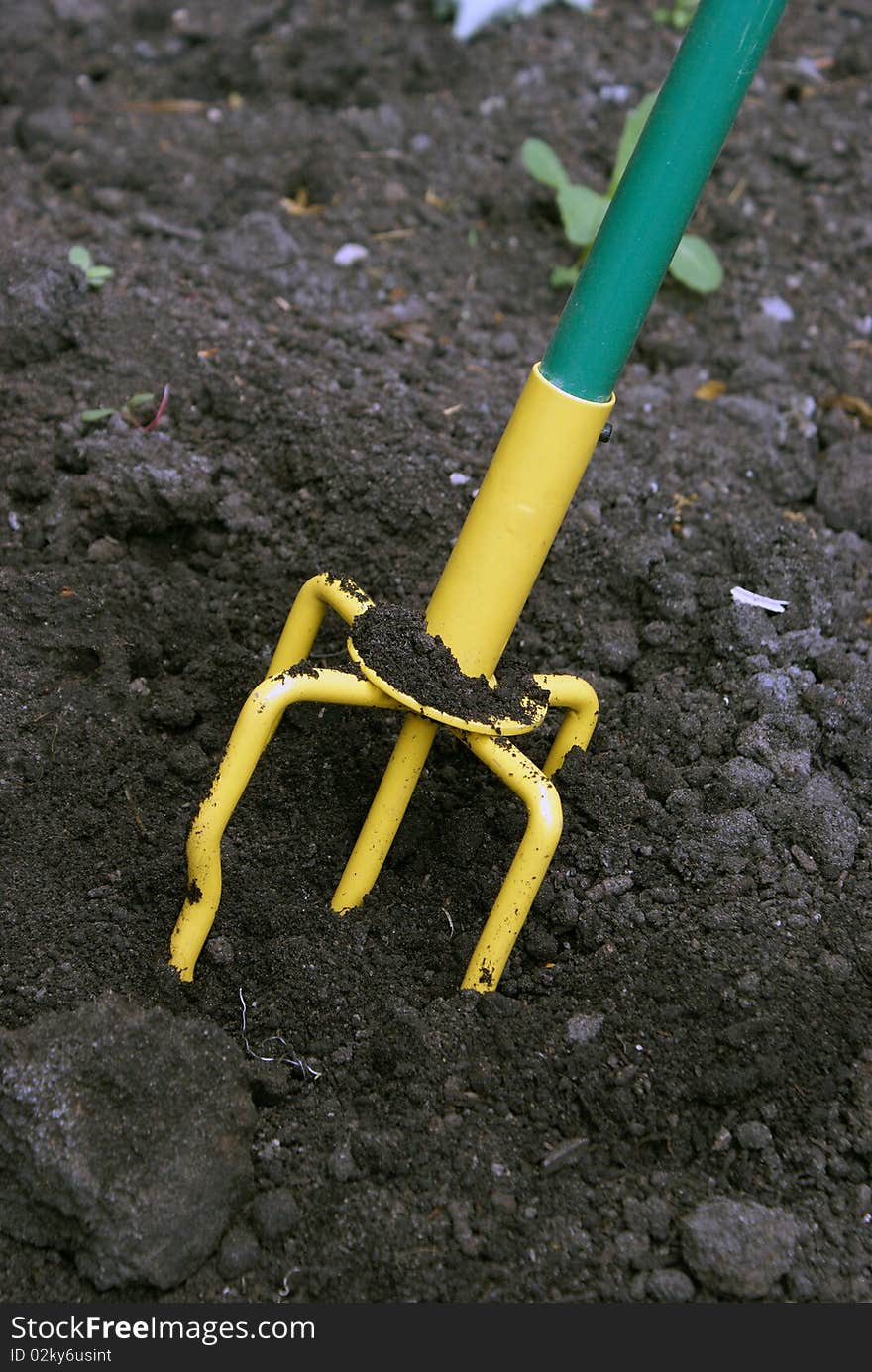 A closeup shot of a hand tiller working the dirt around.