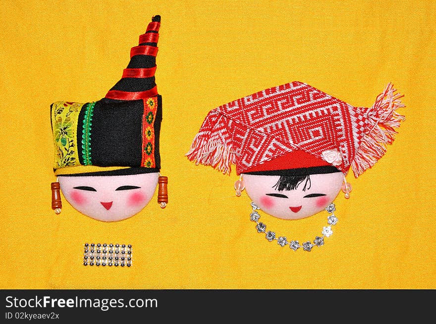 Finery embroidery doll of Chinese minority Chuang's tradtional style. The raiment and hat for men and women in feast day. Finery embroidery doll of Chinese minority Chuang's tradtional style. The raiment and hat for men and women in feast day.