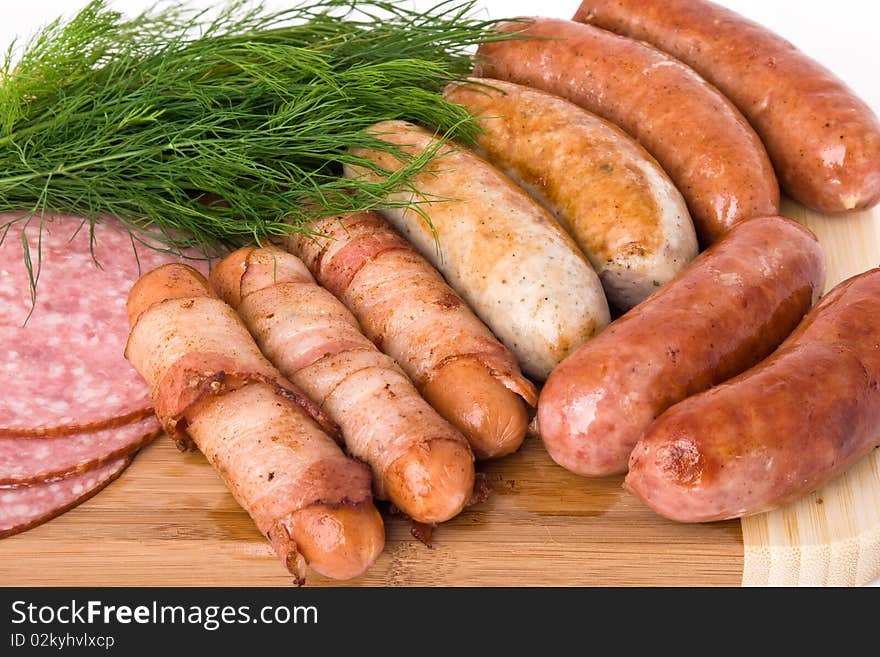 Grilled sausages on wooden plate