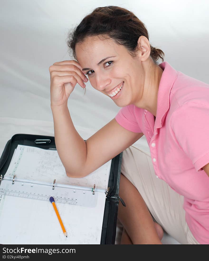 Woman smiling at camera with full scheduled planner in background. Woman smiling at camera with full scheduled planner in background