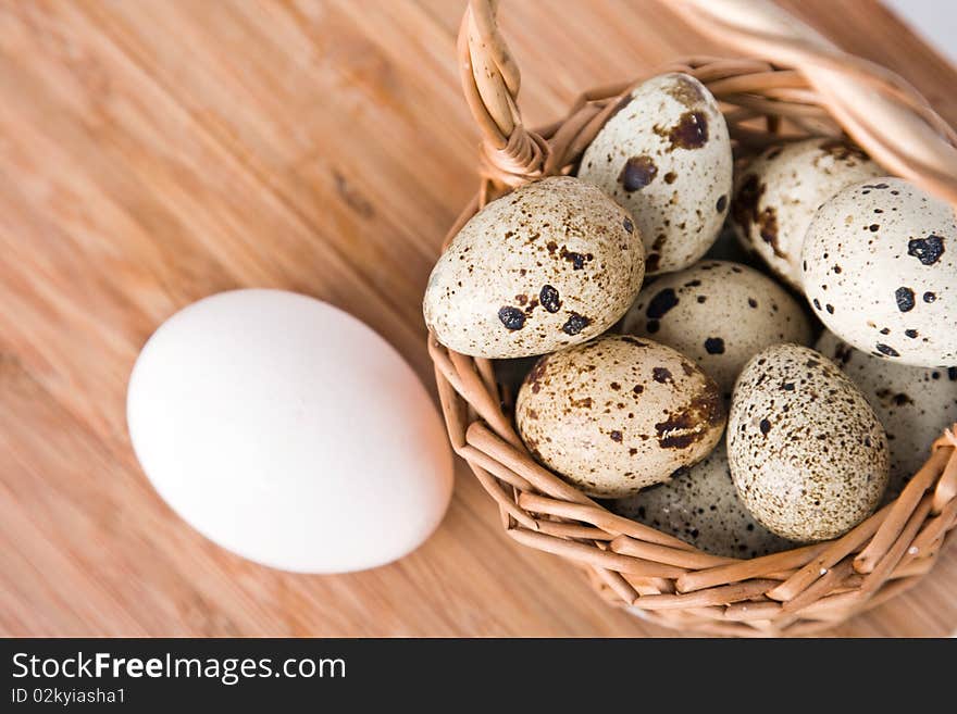 Eggs in basket on a wood background, small focus