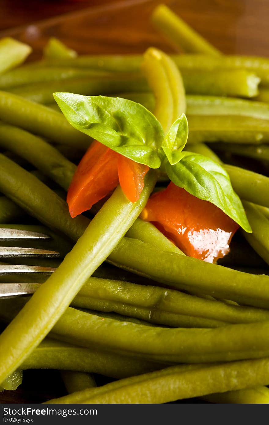 Photo of french beans on a glass platet putted on a wood table