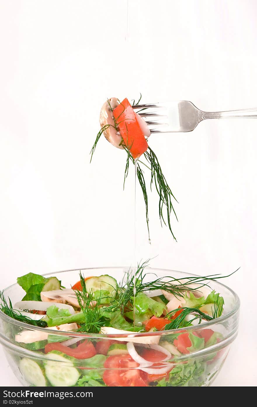 Closeup of tossed salad in a glass bowl with fork