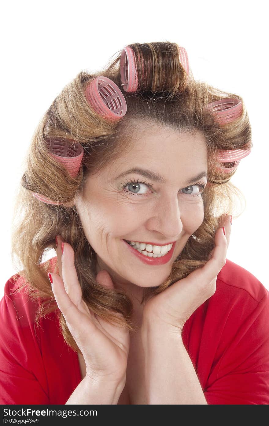 Happy middle-aged woman in red with hair rollers - isolated on white. Happy middle-aged woman in red with hair rollers - isolated on white