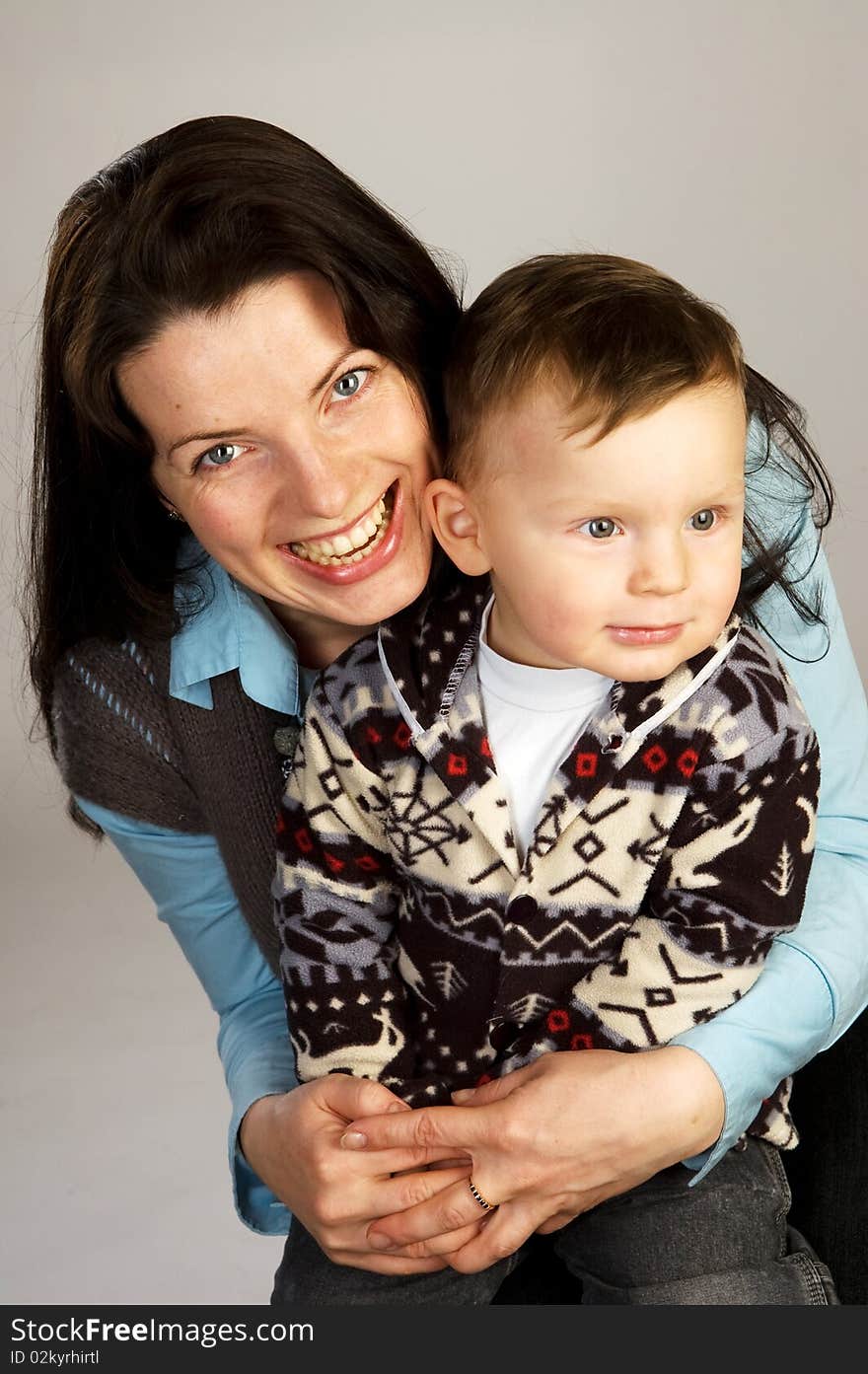 Laughing woman with son, studio shot, gray background. Laughing woman with son, studio shot, gray background