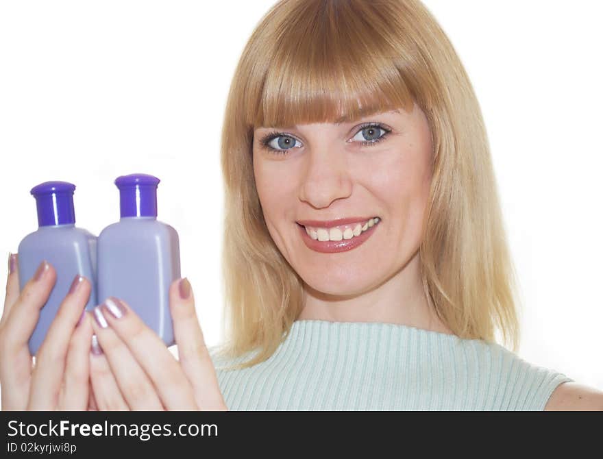 The young woman with cosmetic jars in hands