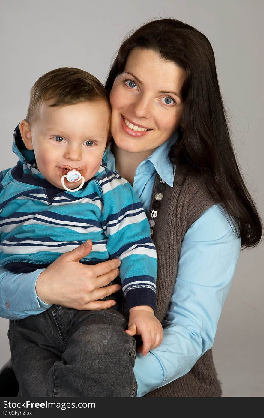 Smiling mother with son, studio shot, gray background. Smiling mother with son, studio shot, gray background