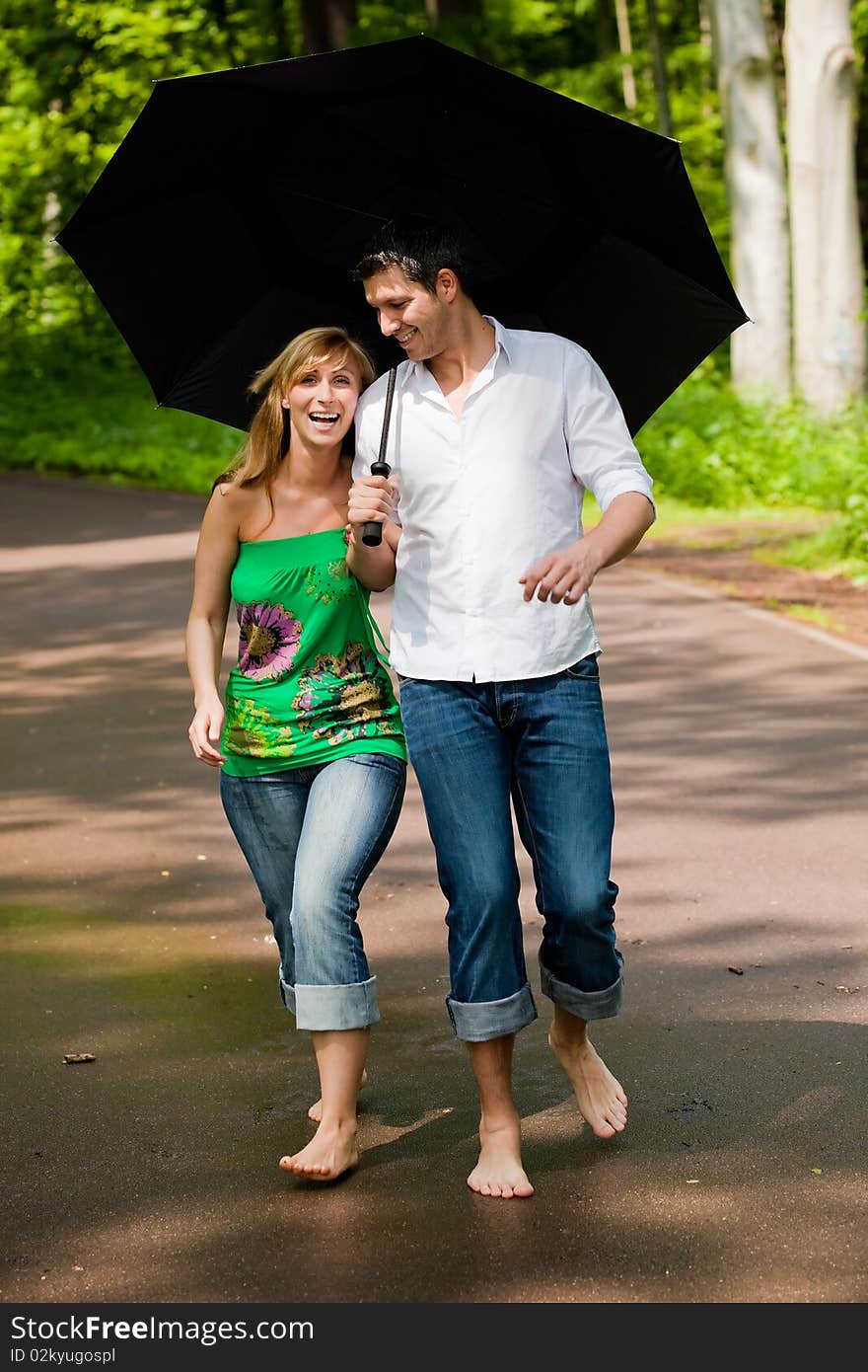 Couple standing in park on rainy summer days. Couple standing in park on rainy summer days