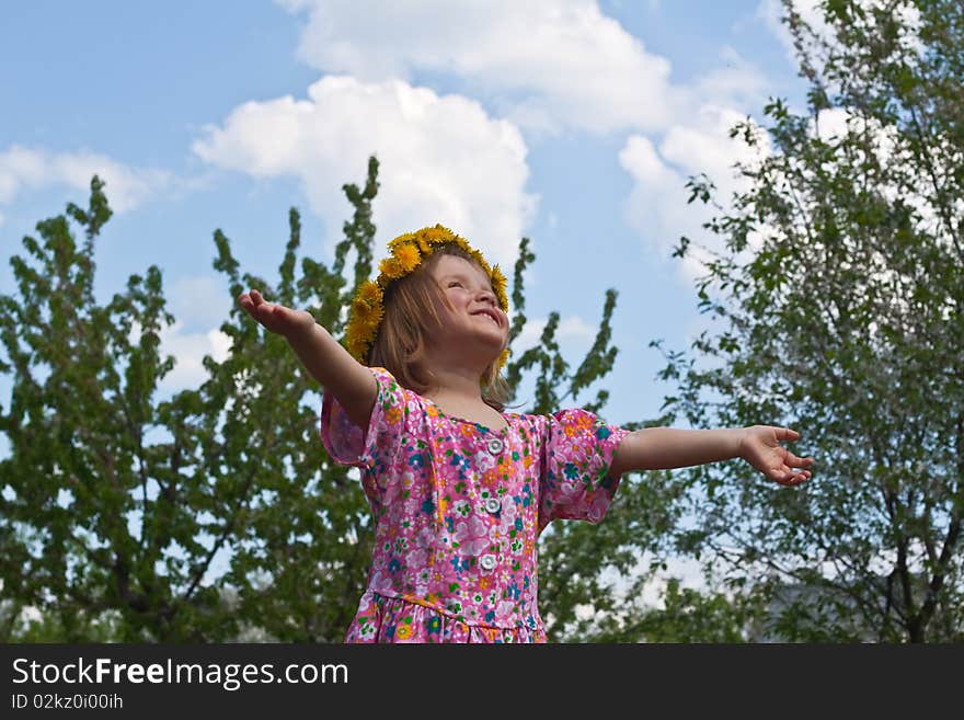 Little girl in dandelion crown looking upwards. Little girl in dandelion crown looking upwards