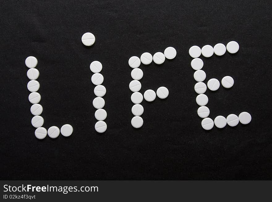 Word a life combined from white round tablets. Word a life combined from white round tablets